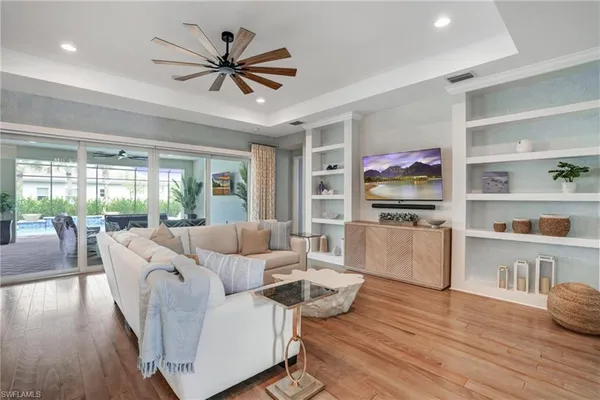 a living room with furniture flat screen tv and wooden floor