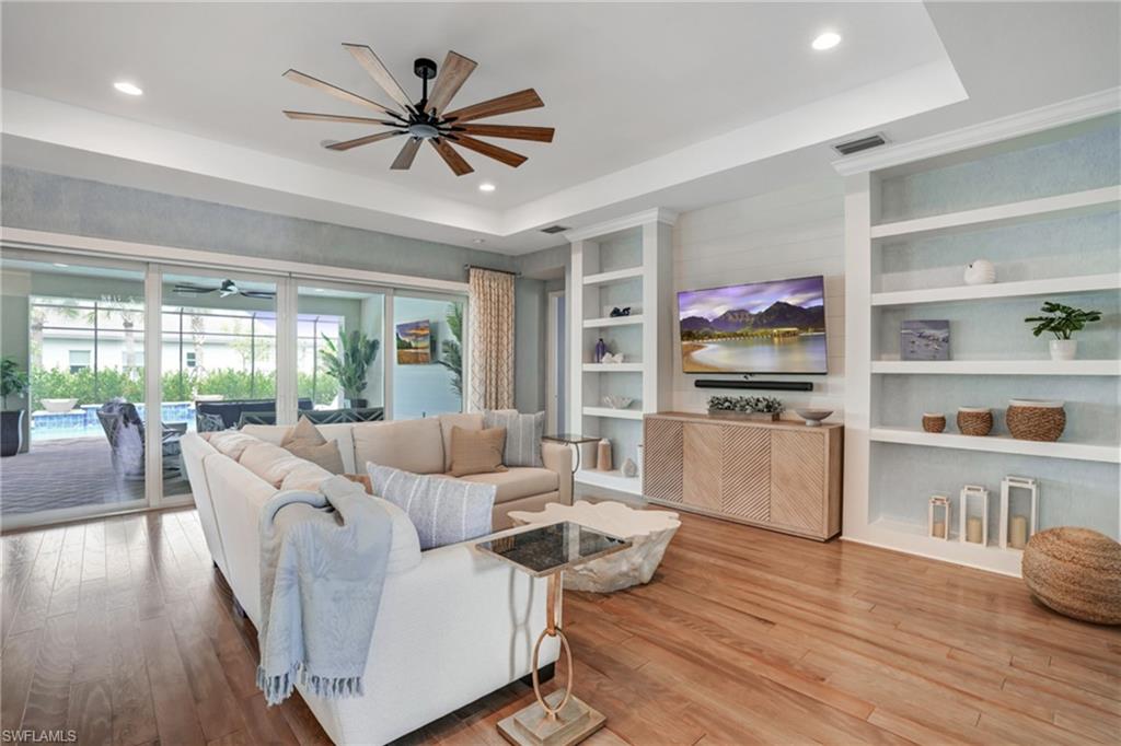 12068 Azalea Way Naples, FL 34120 - Photo 22 of 50 a living room with furniture flat screen tv and wooden floor