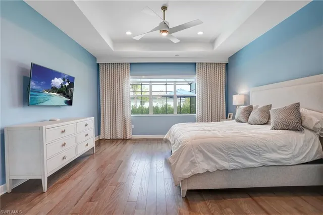 a bedroom with a large bed and a flat tv screen on dresser