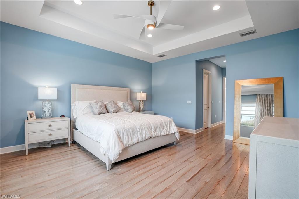 12068 Azalea Way Naples, FL 34120 - Photo 28 of 50 a bedroom with a bed and wooden floor