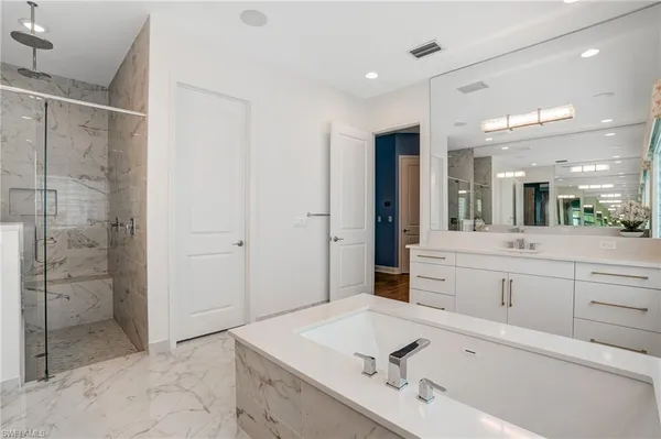 a bathroom with a tub sink and mirror