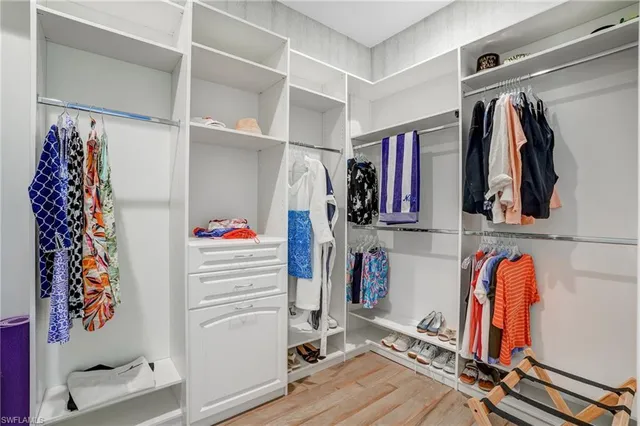 a view of walk in closet with clothes and shoes