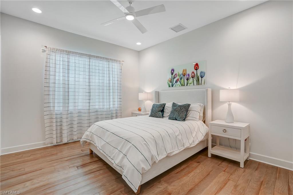 12068 Azalea Way Naples, FL 34120 - Photo 33 of 50 a bedroom with a bed and a night stand