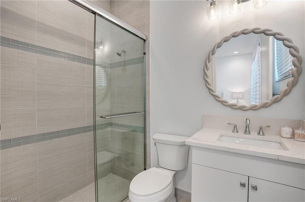 12068 Azalea Way Naples, FL 34120 - Photo 35 of 50 a bathroom with a toilet a sink and mirror