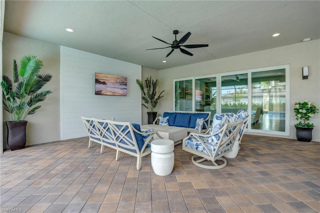 12068 Azalea Way Naples, FL 34120 - Photo 44 of 50 a dining room with furniture potted plants and wooden floor
