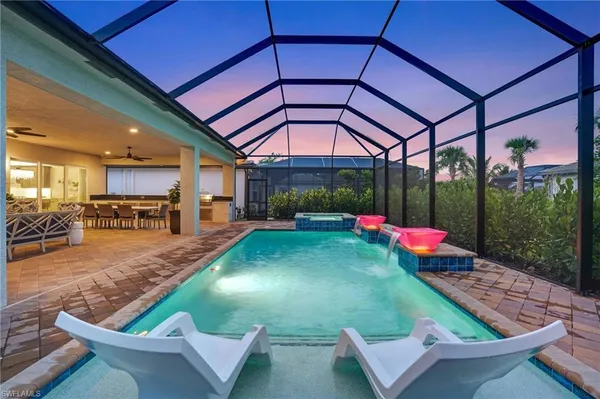 a view of a backyard with table and chairs under an umbrella