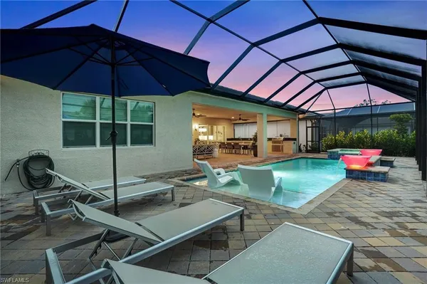 a view of a backyard with table and chairs under an umbrella