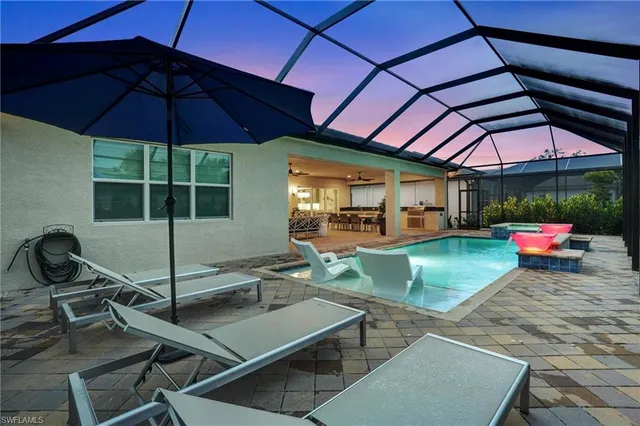 a view of a backyard with table and chairs under an umbrella