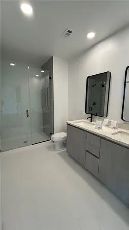 a bathroom with a double vanity sink mirror and bathtub