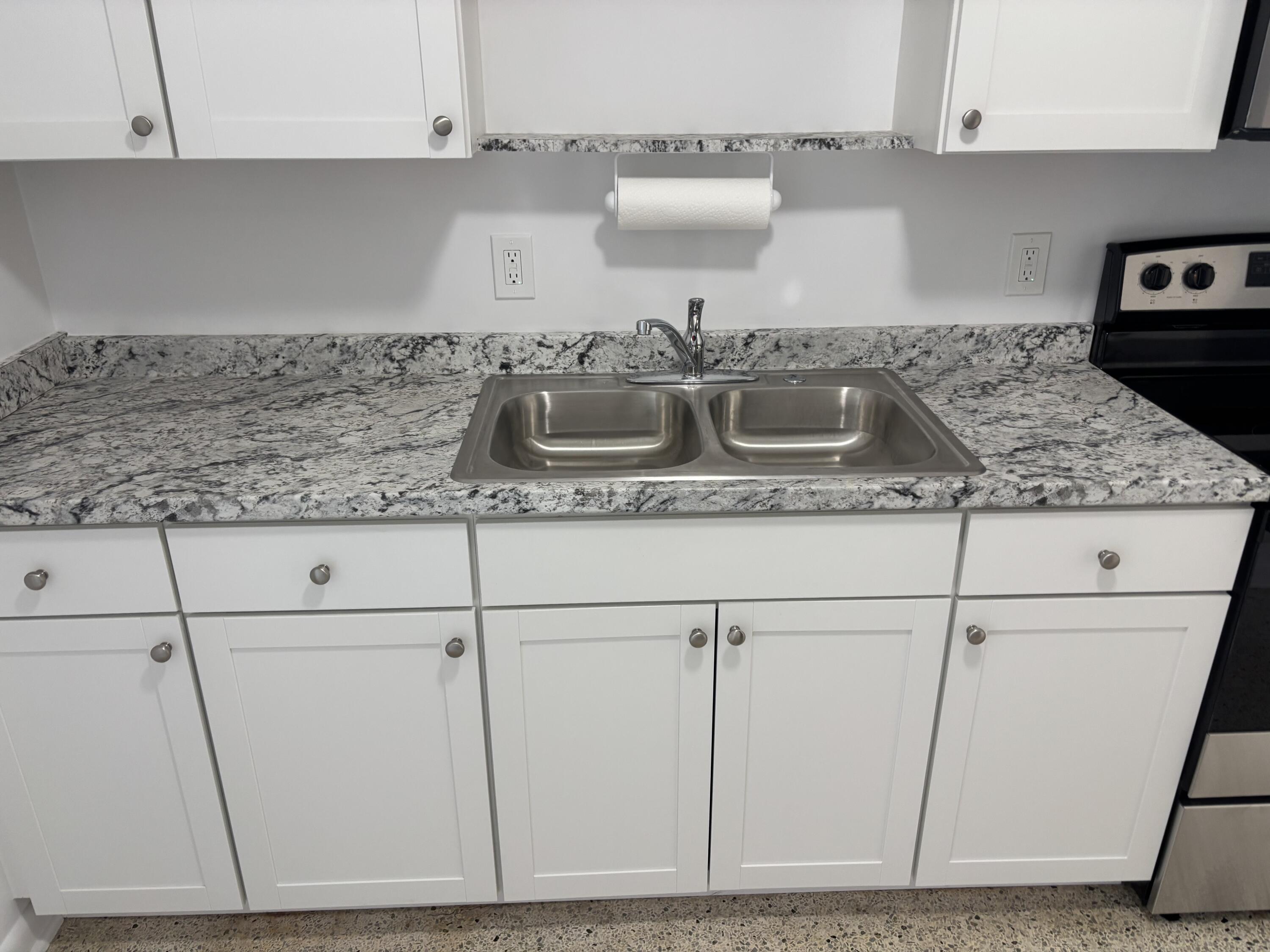 751 Hummingbird Way, Unit 5 North Palm Beach, FL 33408 - Photo 3 of 18 a kitchen with a sink a stove and cabinets