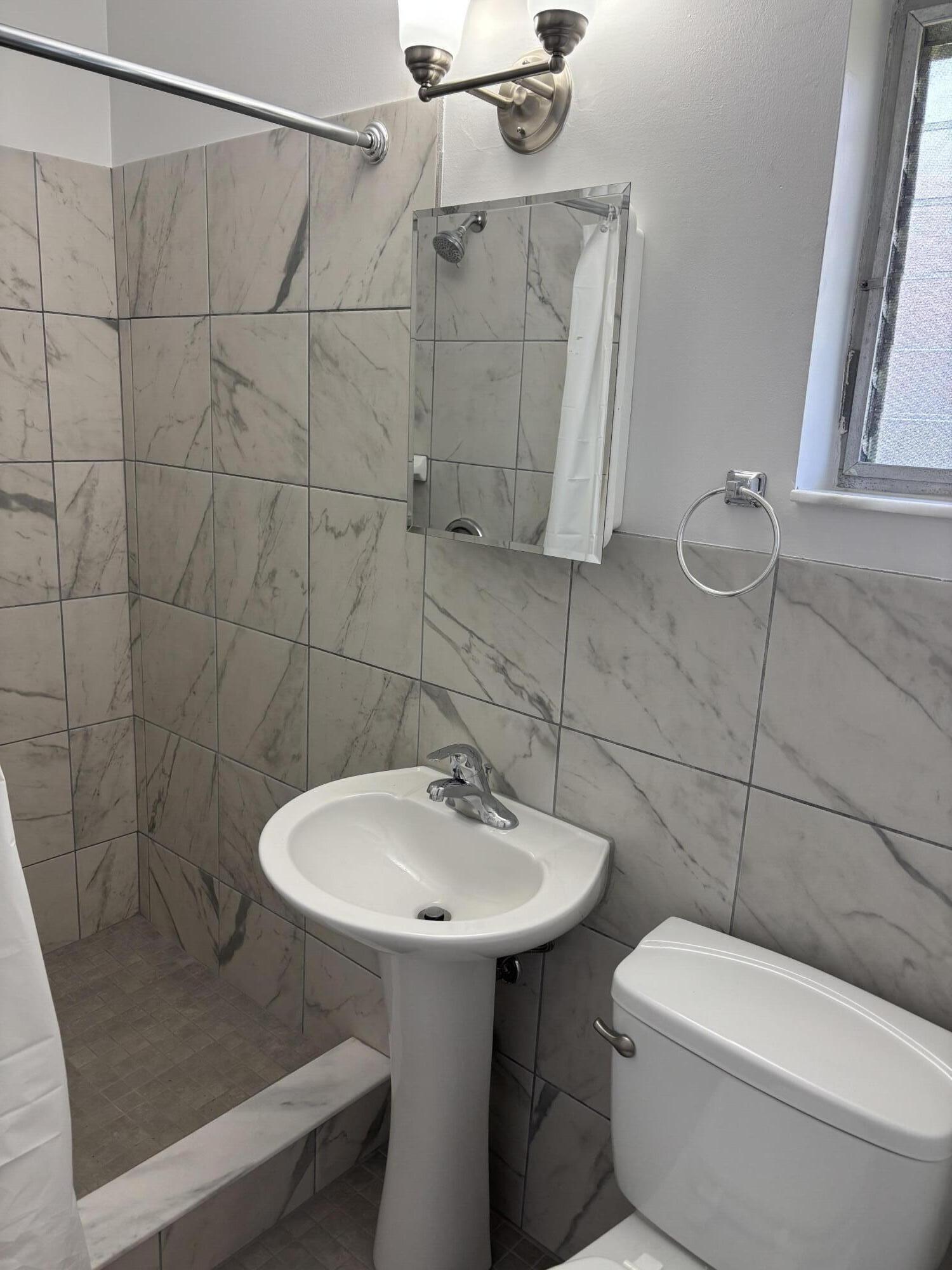 751 Hummingbird Way, Unit 5 North Palm Beach, FL 33408 - Photo 7 of 18 a bathroom with a sink a toilet and shower