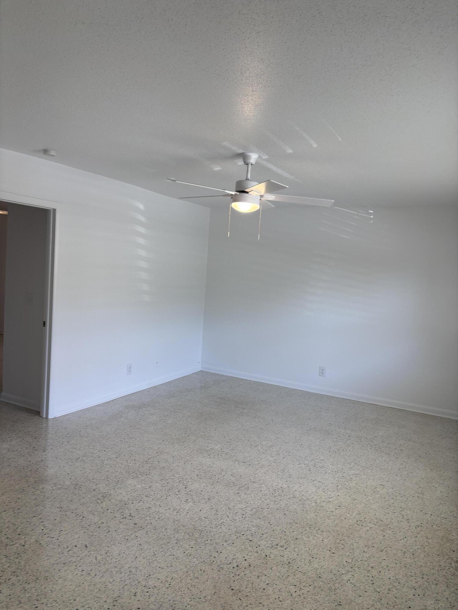 751 Hummingbird Way, Unit 5 North Palm Beach, FL 33408 - Photo 10 of 18 a view of an empty room with a chandelier fan
