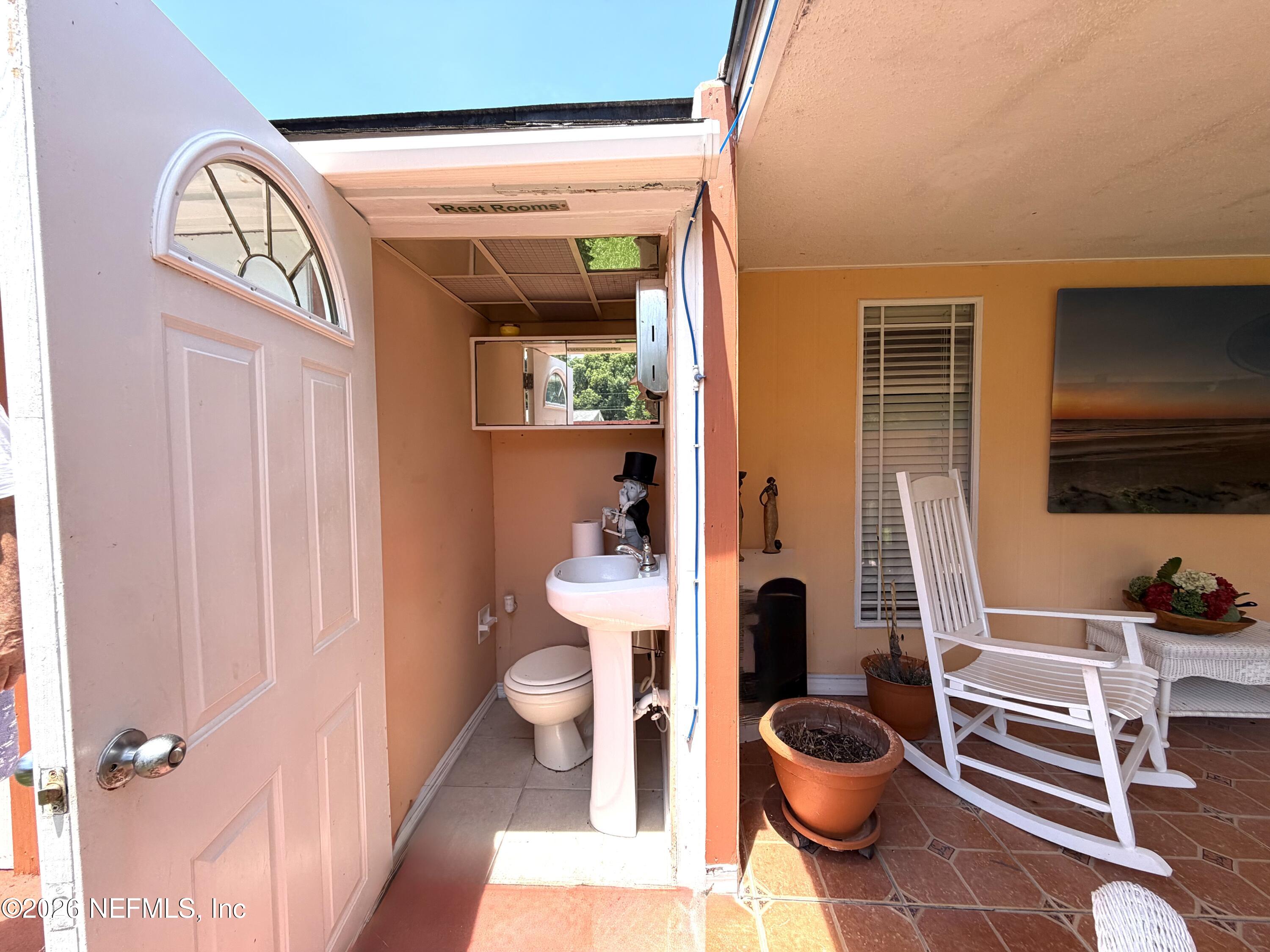 4127 Springwood Road Jacksonville, FL 32207 - Photo 38 of 63 a bathroom with a toilet a sink and mirror