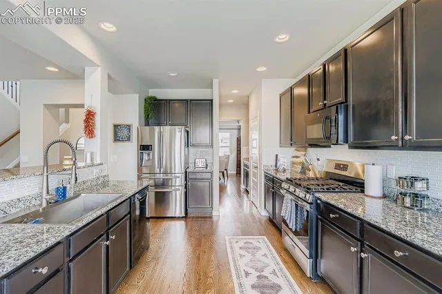 a kitchen with stainless steel appliances granite countertop a sink stove and refrigerator