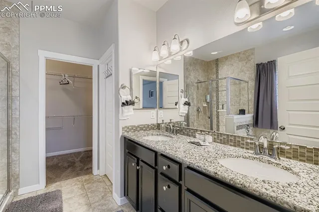 a bathroom with a granite countertop double vanity sink and mirror