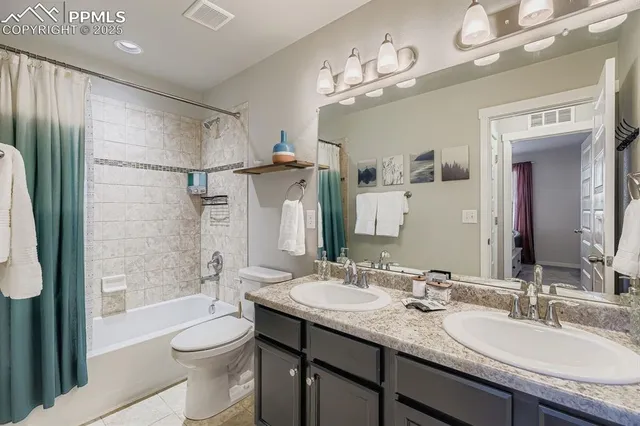 a bathroom with a granite countertop sink a toilet a mirror a bathtub and shower