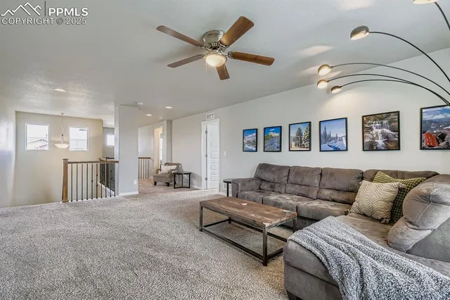 a living room with furniture and a ceiling fan