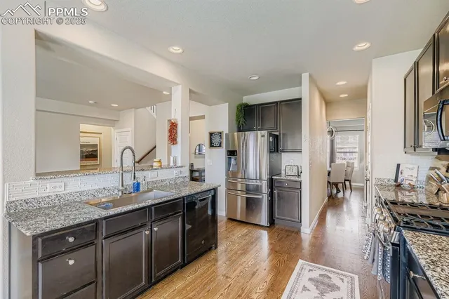a kitchen with stainless steel appliances granite countertop a stove refrigerator and cabinets