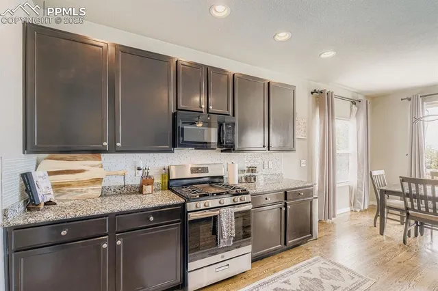 a kitchen with stainless steel appliances granite countertop a sink stove and microwave