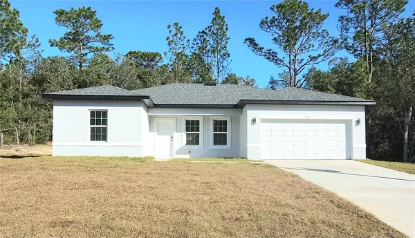 a front view of a house with a garden and yard