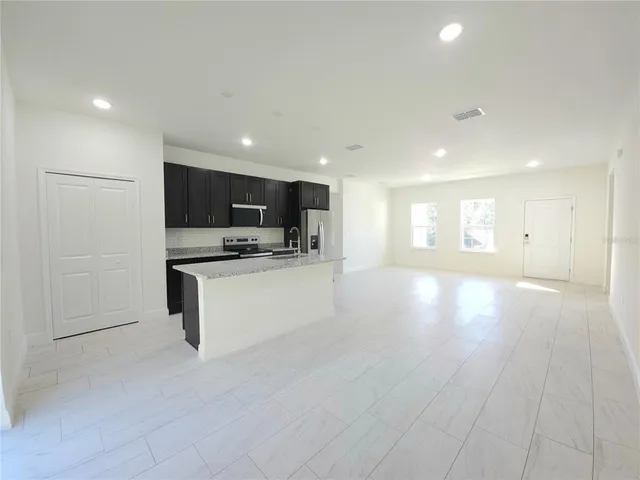 a view of kitchen with cabinets and refrigerator