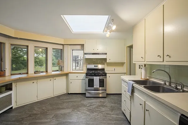 a kitchen with a stove sink and cabinets