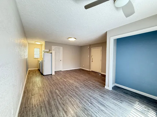 a view of empty room with wooden floor