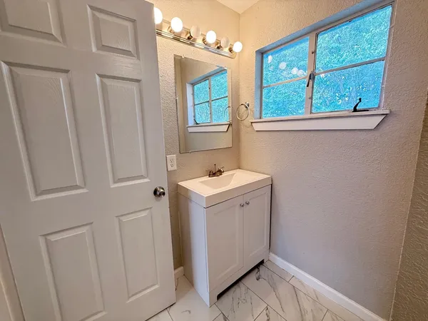 a utility room with a sink a mirror and a window