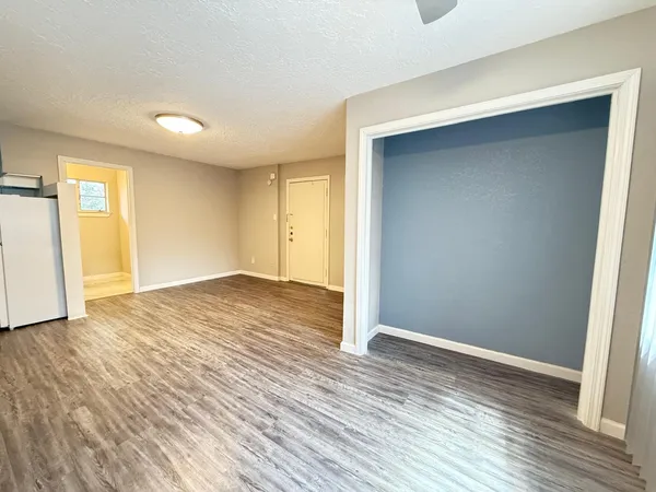 an empty room with wooden floor and entrance