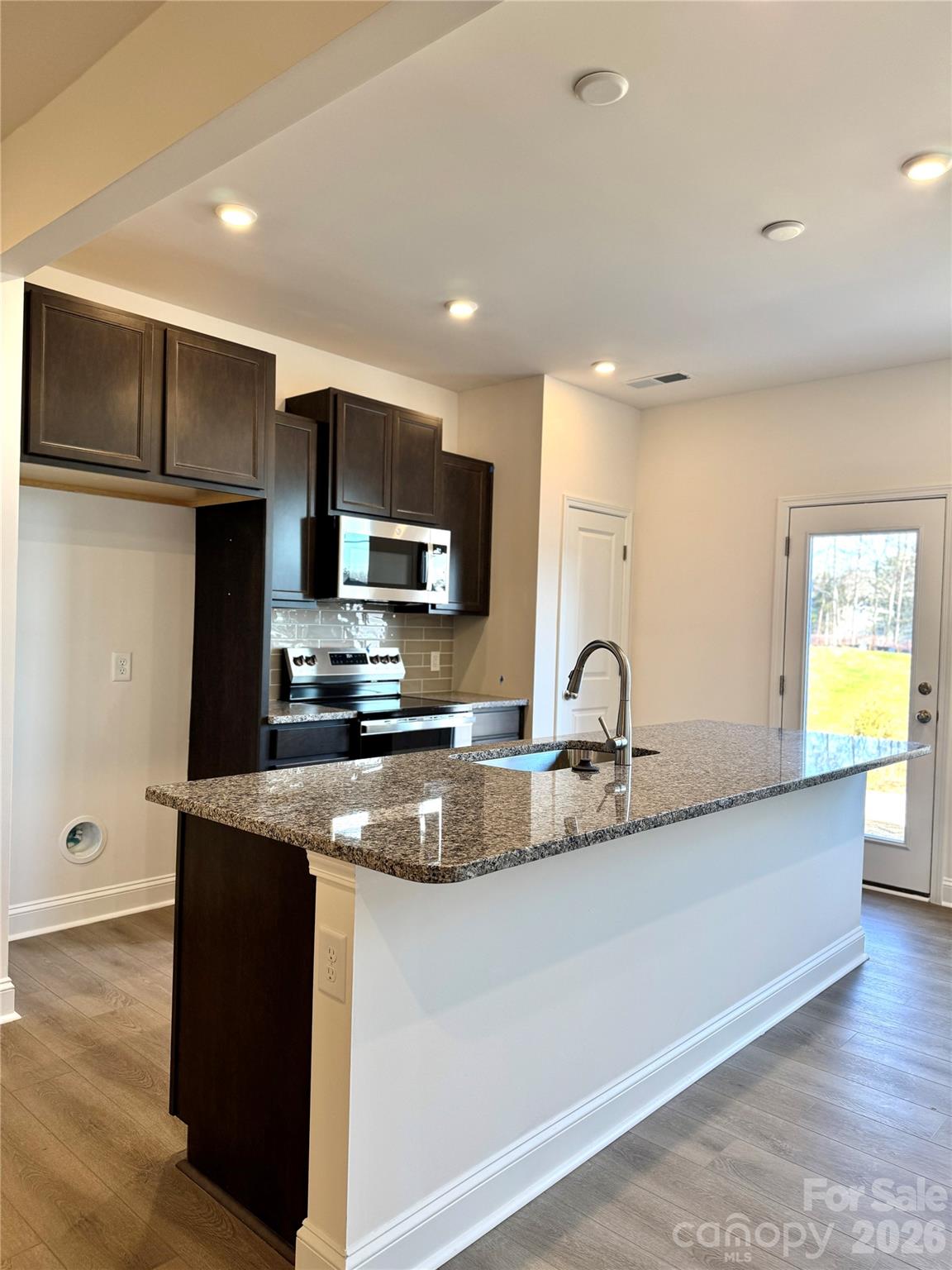 7709 Ethora Way Charlotte, NC 28216 - Photo 11 of 33 a kitchen with stainless steel appliances granite countertop a sink a stove and a refrigerator