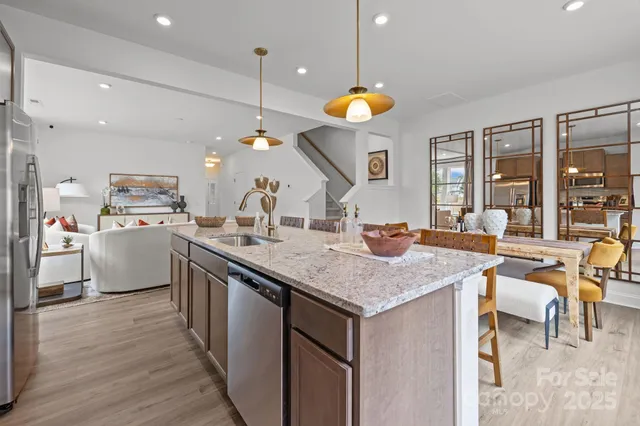 a kitchen with a table chairs sink and wooden floor