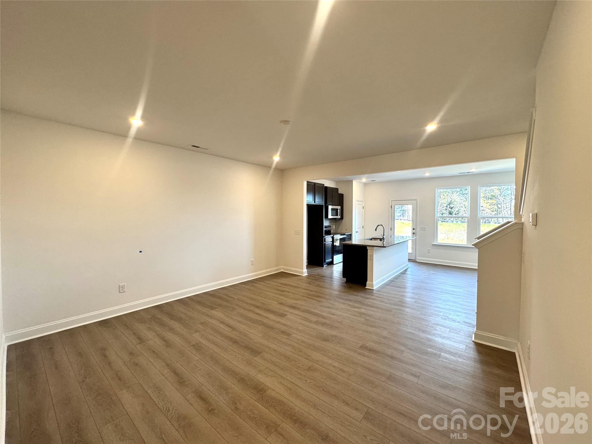 7709 Ethora Way Charlotte, NC 28216 - Photo 6 of 33 a view of an empty room with wooden floor and a window