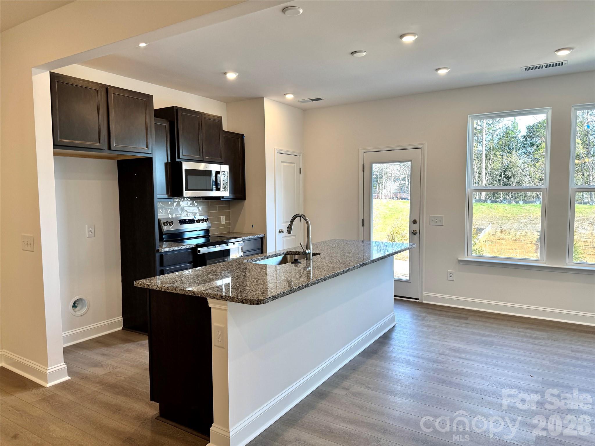 7709 Ethora Way Charlotte, NC 28216 - Photo 8 of 33 a kitchen with kitchen island granite countertop a sink and a refrigerator