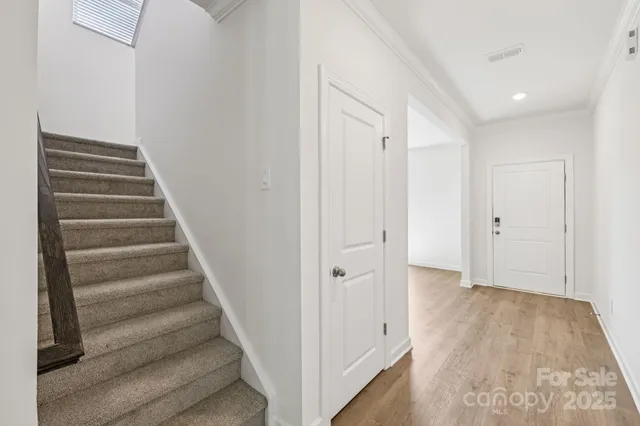 a view of a hallway with wooden floor and entryway