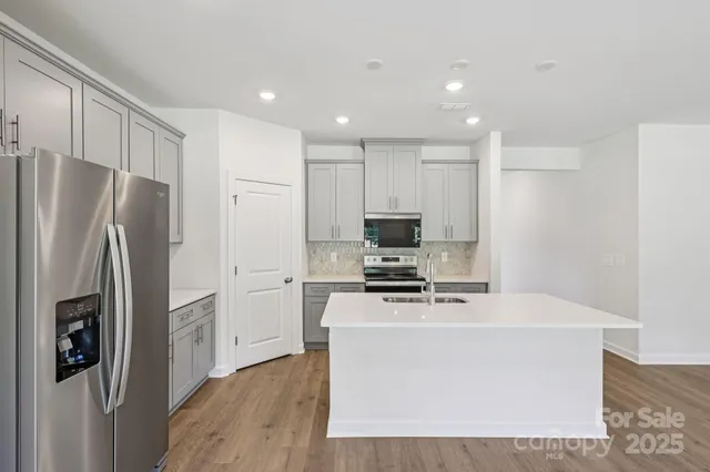 a kitchen with stainless steel appliances a refrigerator stove and microwave