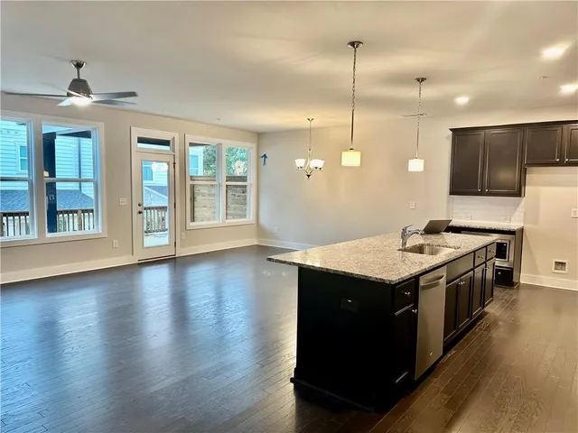 a kitchen with stainless steel appliances granite countertop wooden cabinets a sink and a refrigerator