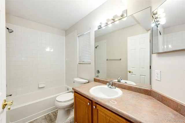 a bathroom with a sink a toilet a large mirror and shower