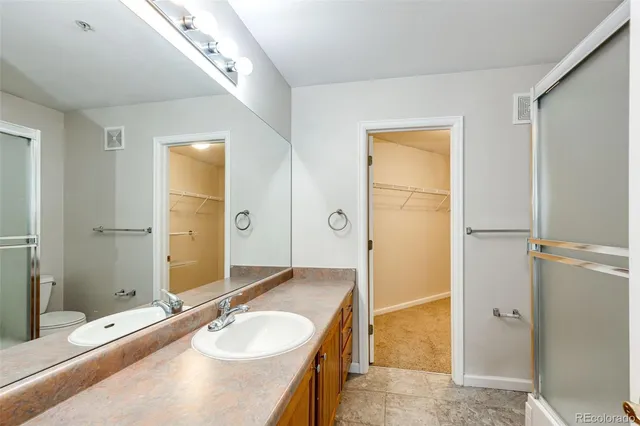 a spacious bathroom with a granite countertop sink and a mirror