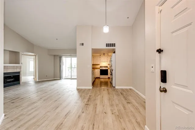 a view of empty room with wooden floor and fireplace