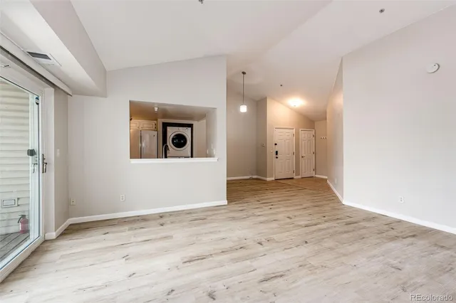 a view of a big room with wooden floor and windows
