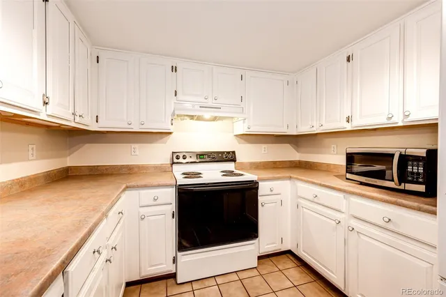 a kitchen with granite countertop white cabinets and white appliances