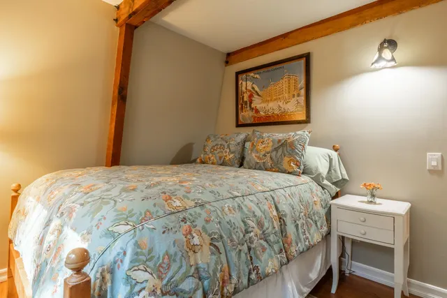 a bedroom with a bed and painting on the wall