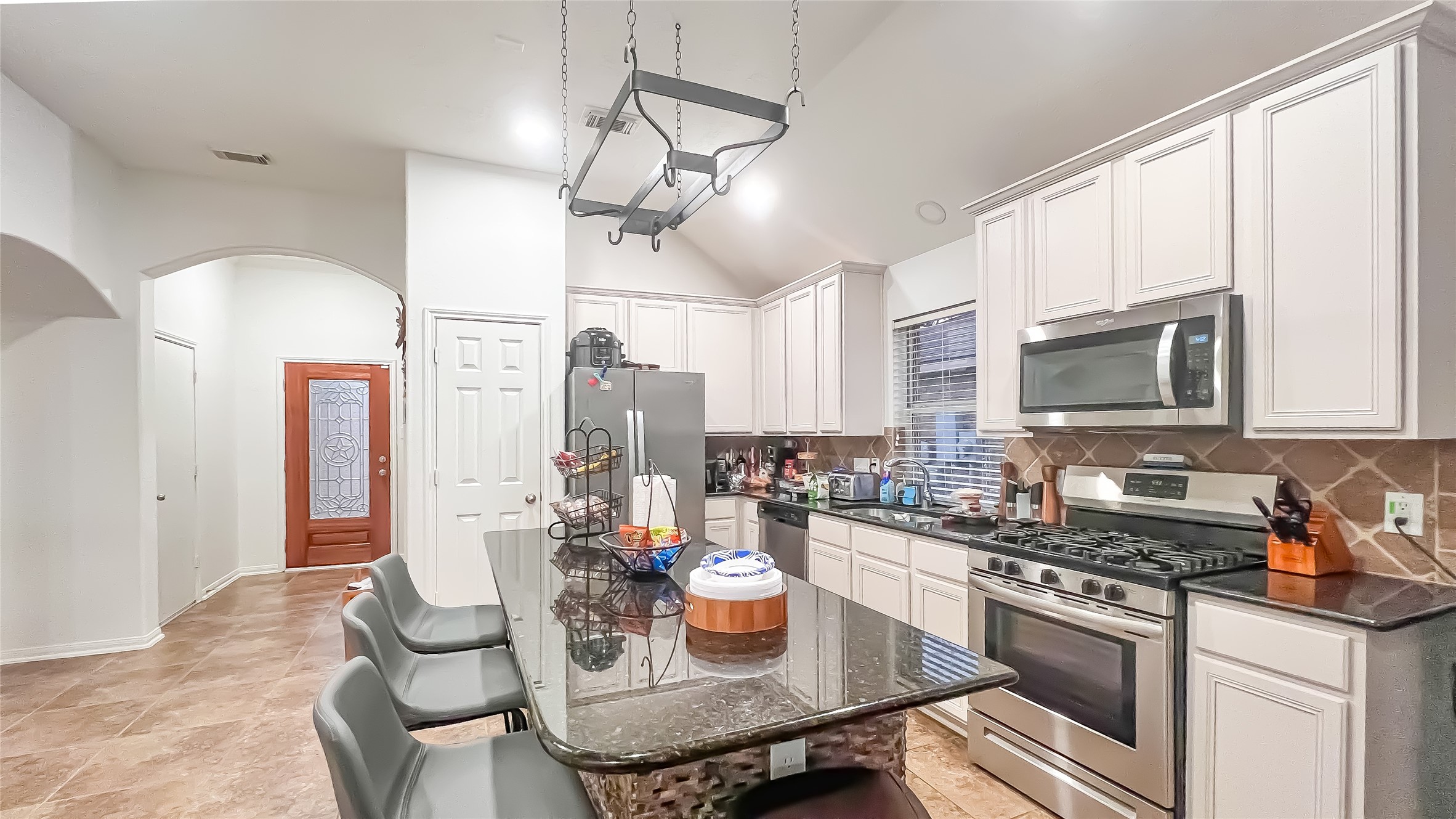 9923 Opal Rock Drive Rosharon, TX 77583 - Photo 4 of 20 a kitchen with a stove a sink dishwasher a dining table and chairs with wooden floor