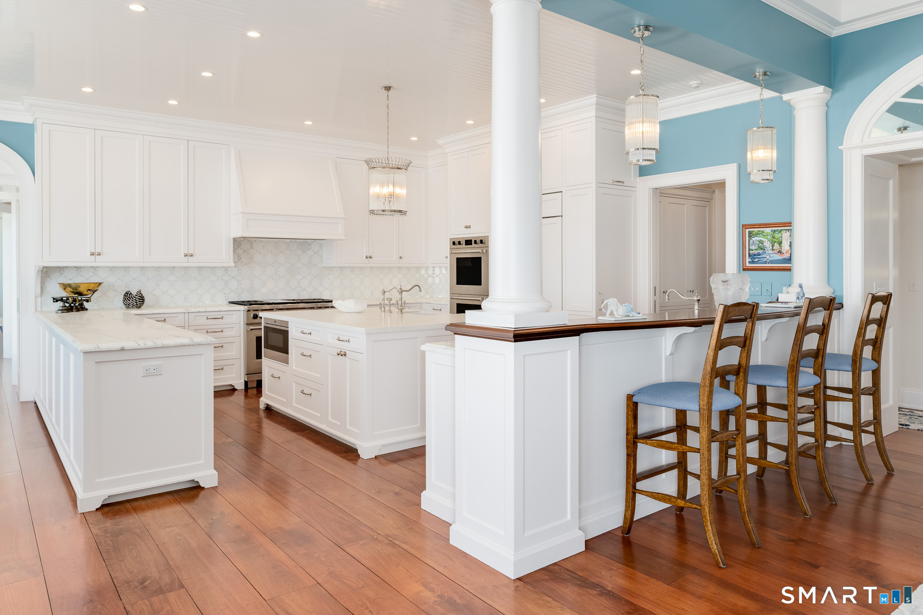 10 Shorehaven Road Norwalk, CT 06855 - Photo 12 of 33 a kitchen with a table chairs wooden floors and white cabinets