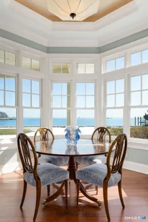 a kitchen with a table chairs wooden floors and white cabinets