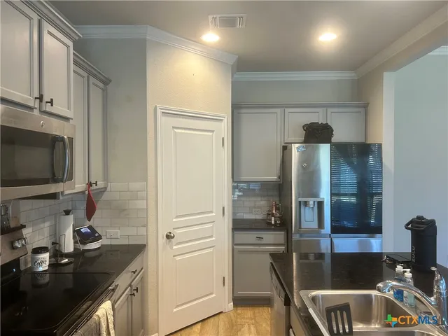 a kitchen with a refrigerator a sink and a stove top oven
