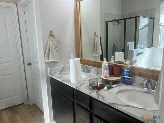 a bathroom with double vanity sinks and a mirror