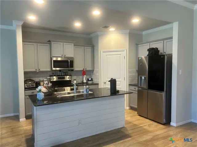 a kitchen with a refrigerator and a sink