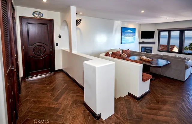 a living room with stainless steel appliances furniture a rug and a view of kitchen