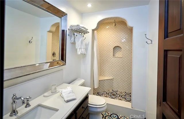 a bathroom with a granite countertop sink toilet and shower